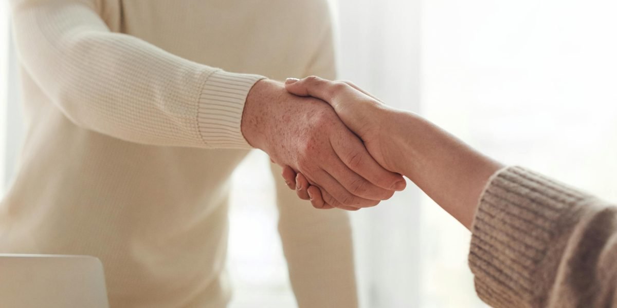 Two business partners shaking hands, symbolizing trust and a long-term professional relationship.