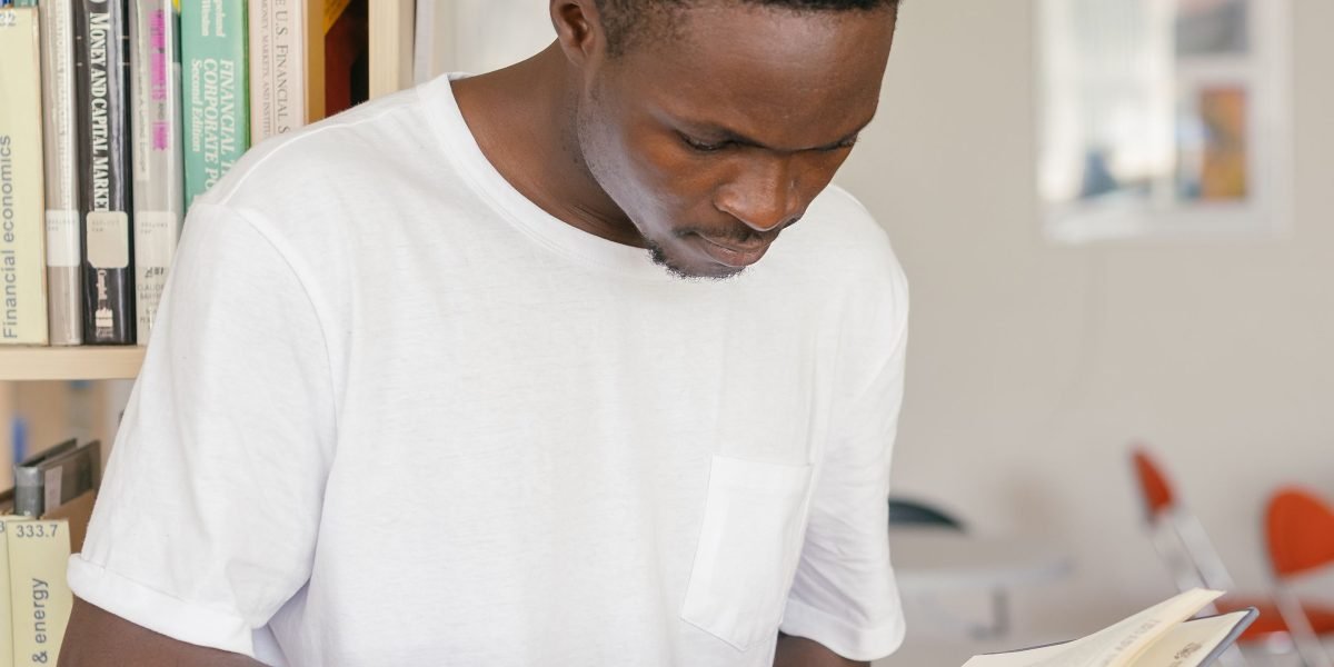 A focused individual absorbed in reading, symbolizing the foundational knowledge gained from investment books.