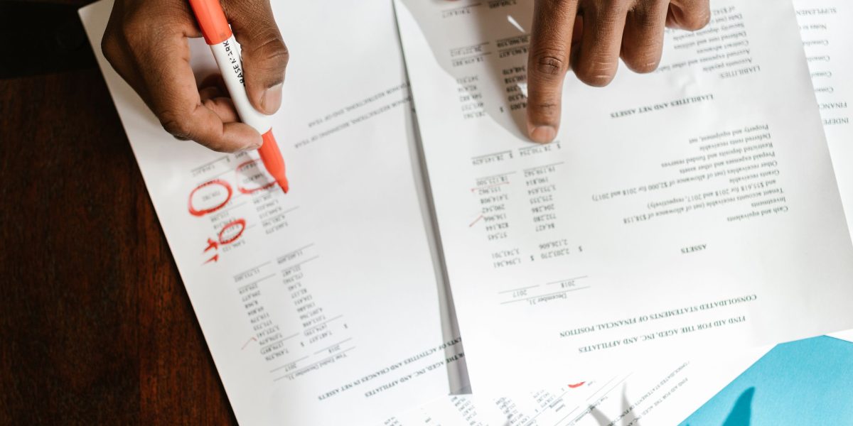 A small business owner meticulously reviewing financial statements and documents to ensure accurate tax preparation.