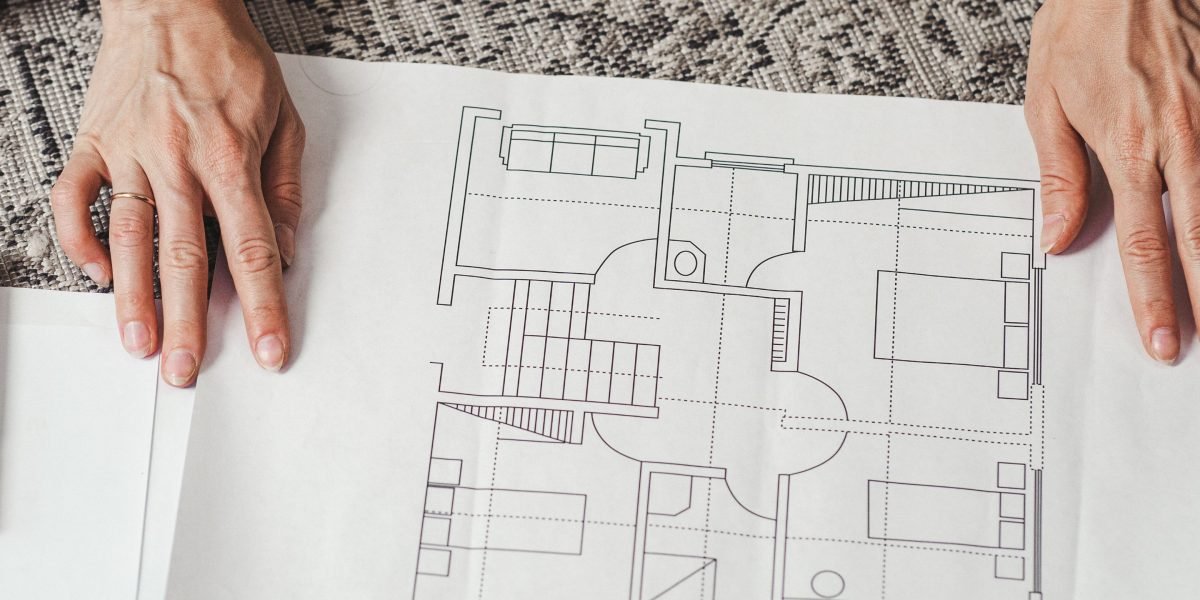 An investor thoughtfully examines architectural blueprints, symbolizing the planning stages of an off-plan property investment.