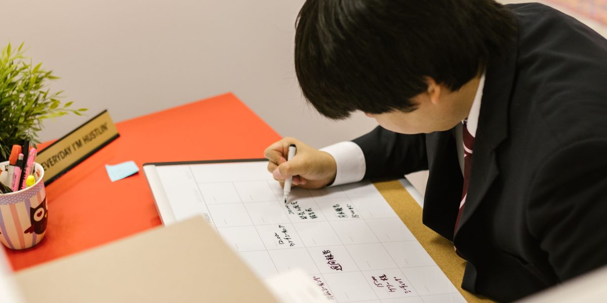 An individual diligently noting important tax deadlines on a calendar to ensure timely compliance.