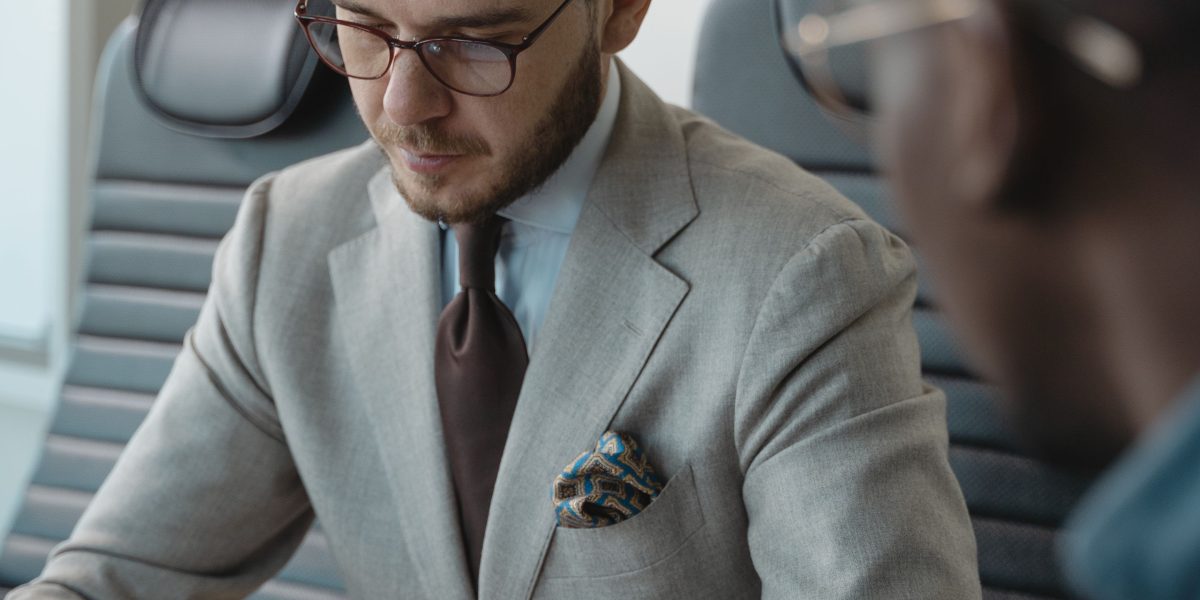 A person looking skeptical or cautious during a business discussion, representing the need to avoid red flags and compliance risks.